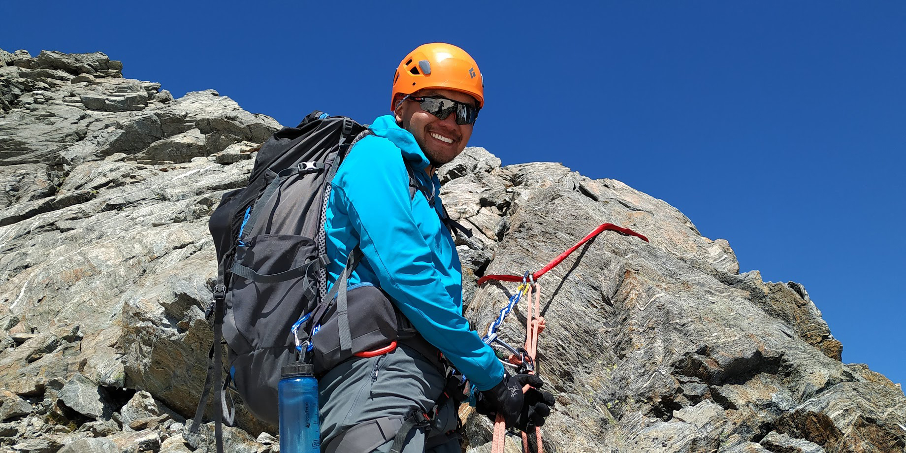 A climber is all smiles descending off Mount Aspiring on the rocky North West Ridge.