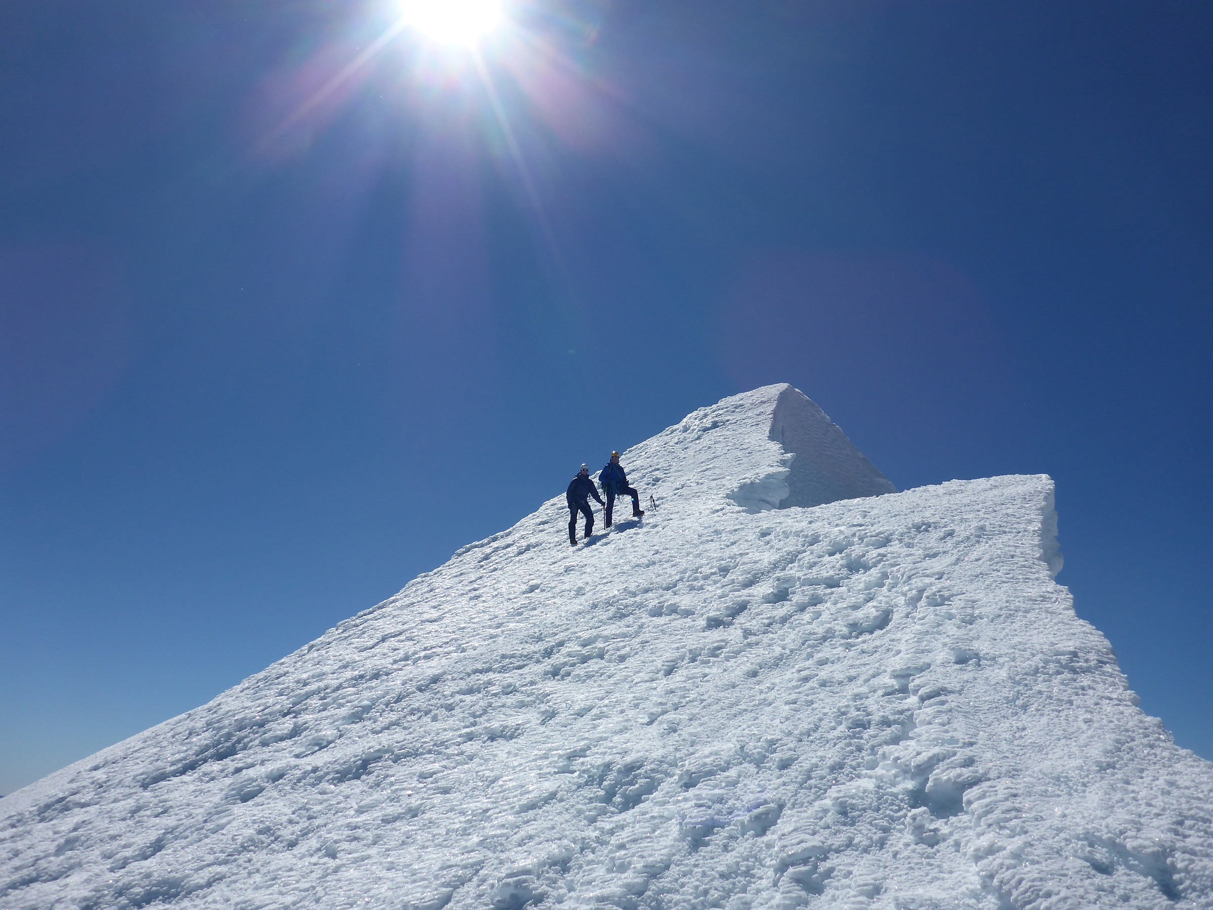 Two climbers descend off the summit of Tititea Mount Aspiring