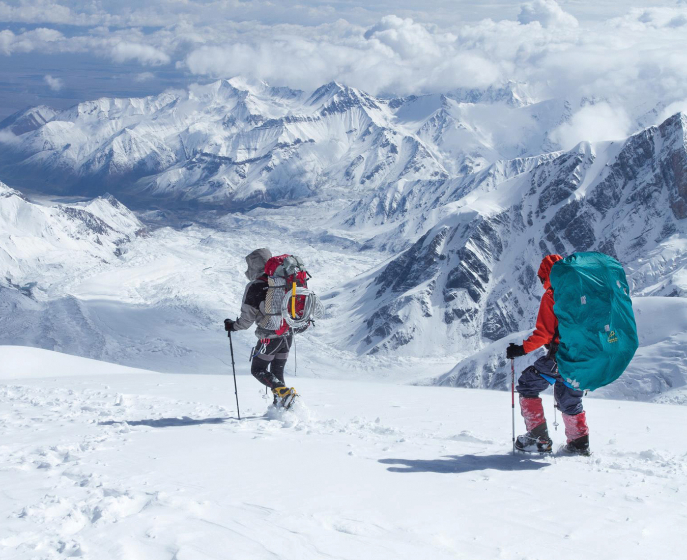 Climbers descend off Peak Lenin alongside the enormous Lenin Glacier and surrounding Pamir mountains.