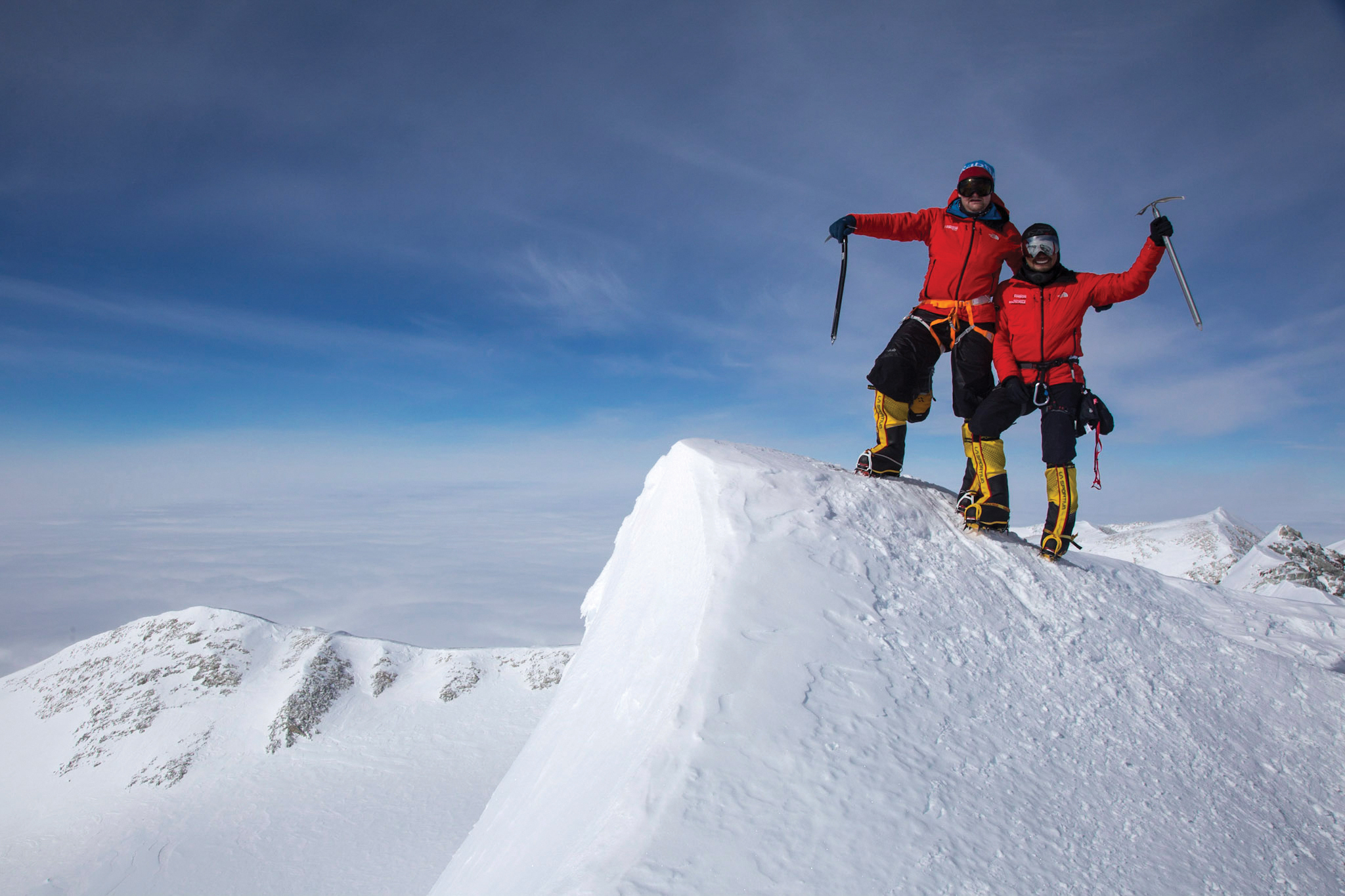 Two climbers stand on top of the summit of Mount Vinson, Antarctica.