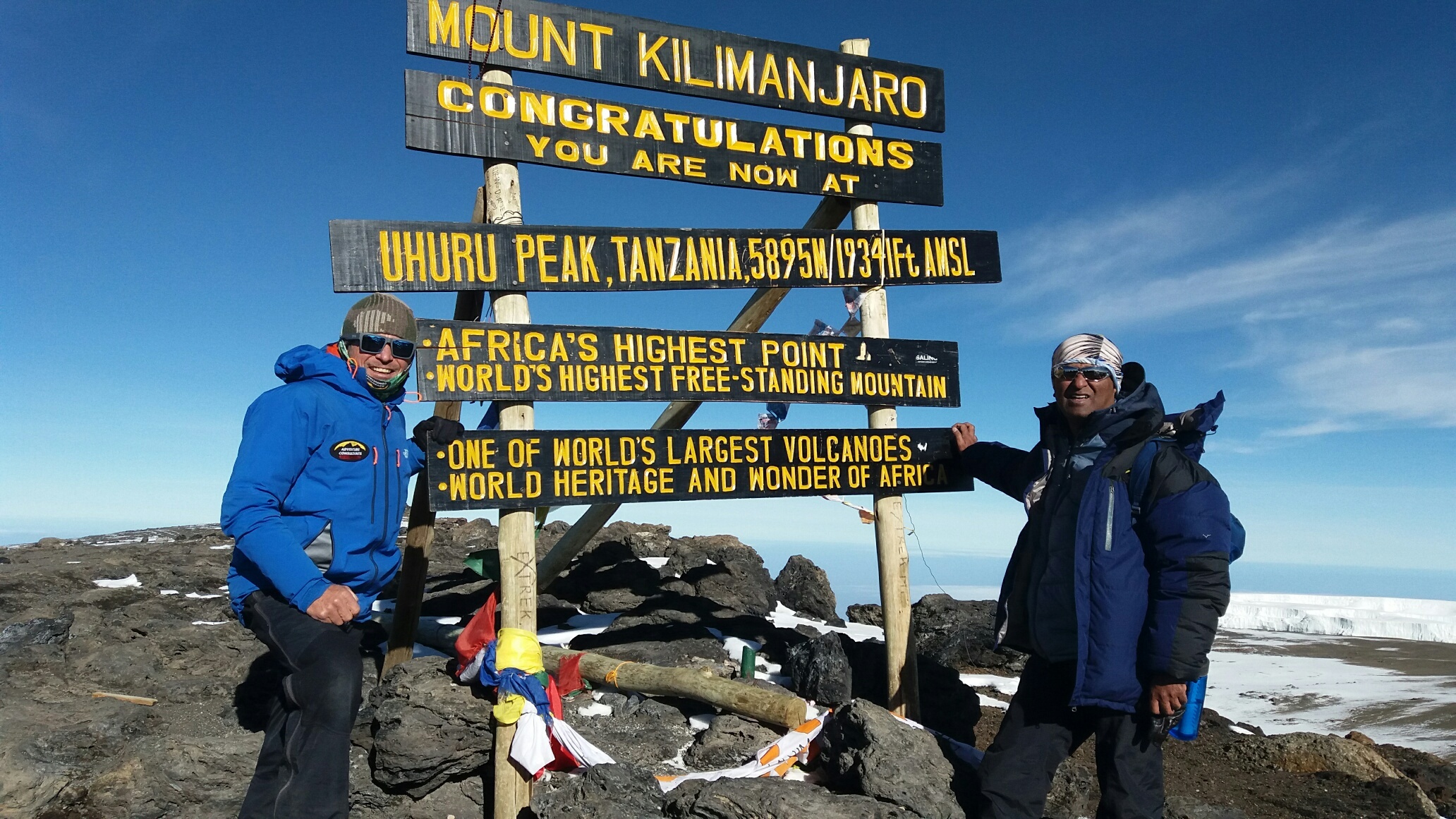 A private luxury Kilimanjaro team celebrate on the summit of Africa's highest peak Kilimanjaro.