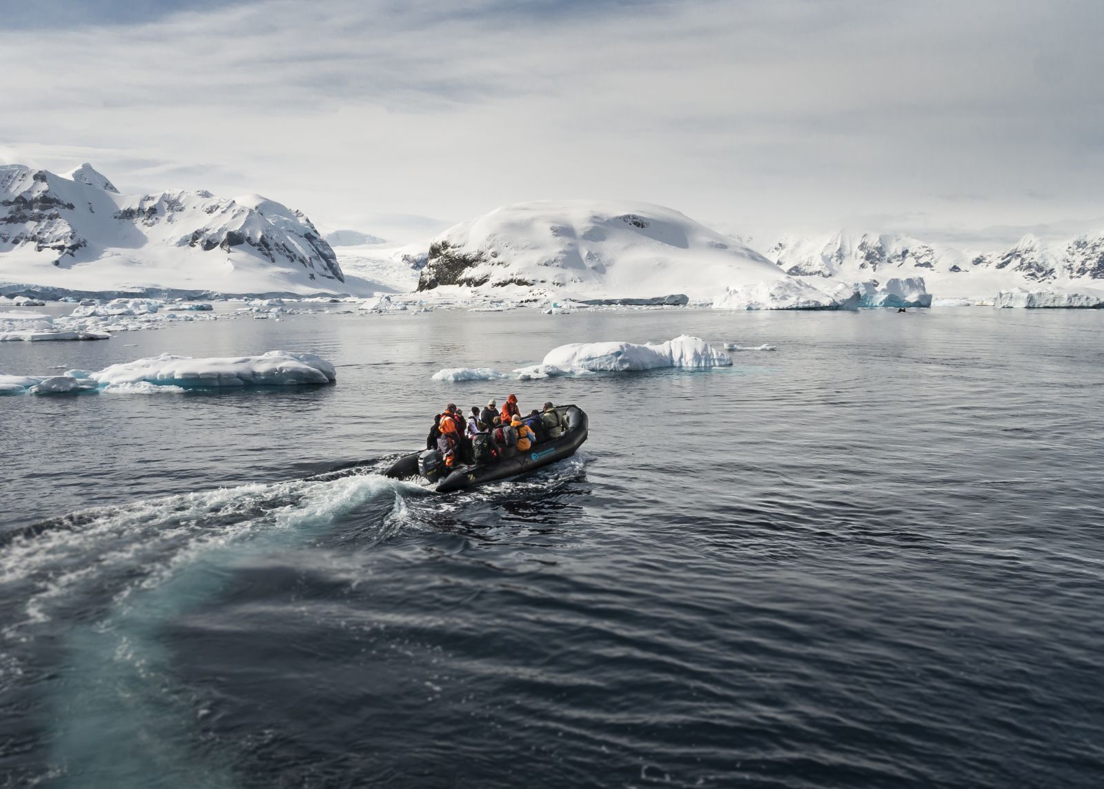 A group takes a zodiac to the shore on the Antarctic Peninsula