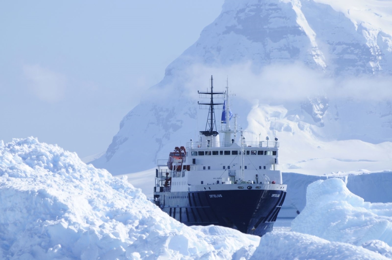 A cruise ship navigates icebergs in the Antarctic peninsula