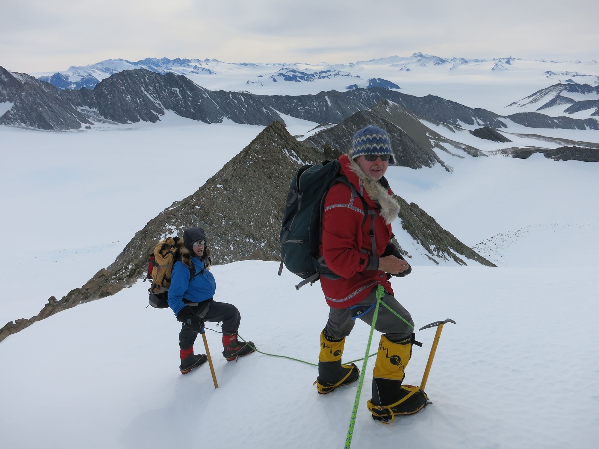 Two climbers pause to rest while climbing a peak in Antarctica
