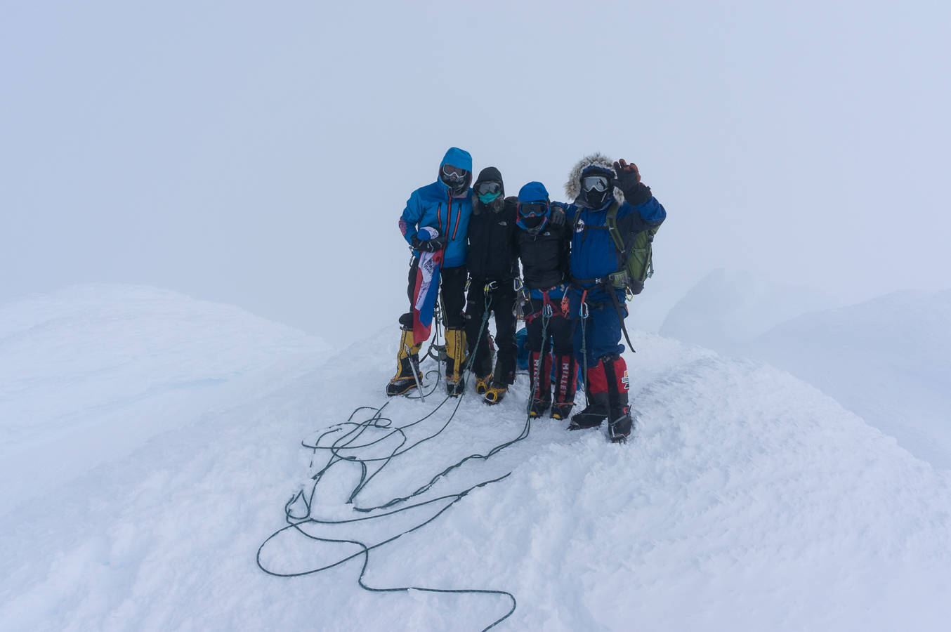A team on Mt Sidley summit in cloud.