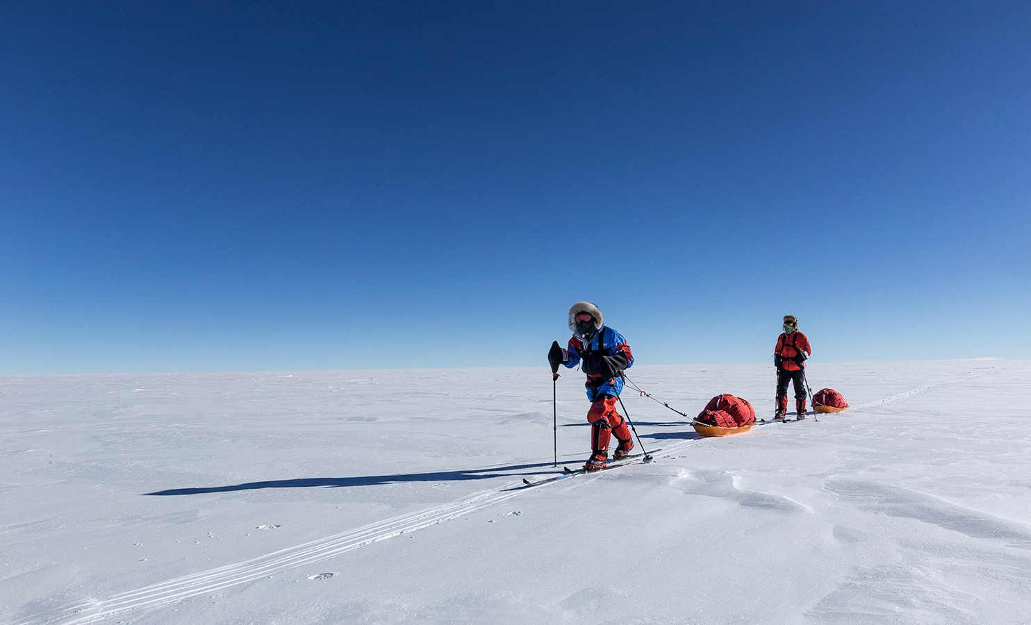 Skier tow sleds across the vast expanse of interior Antarctica to the South Pole.