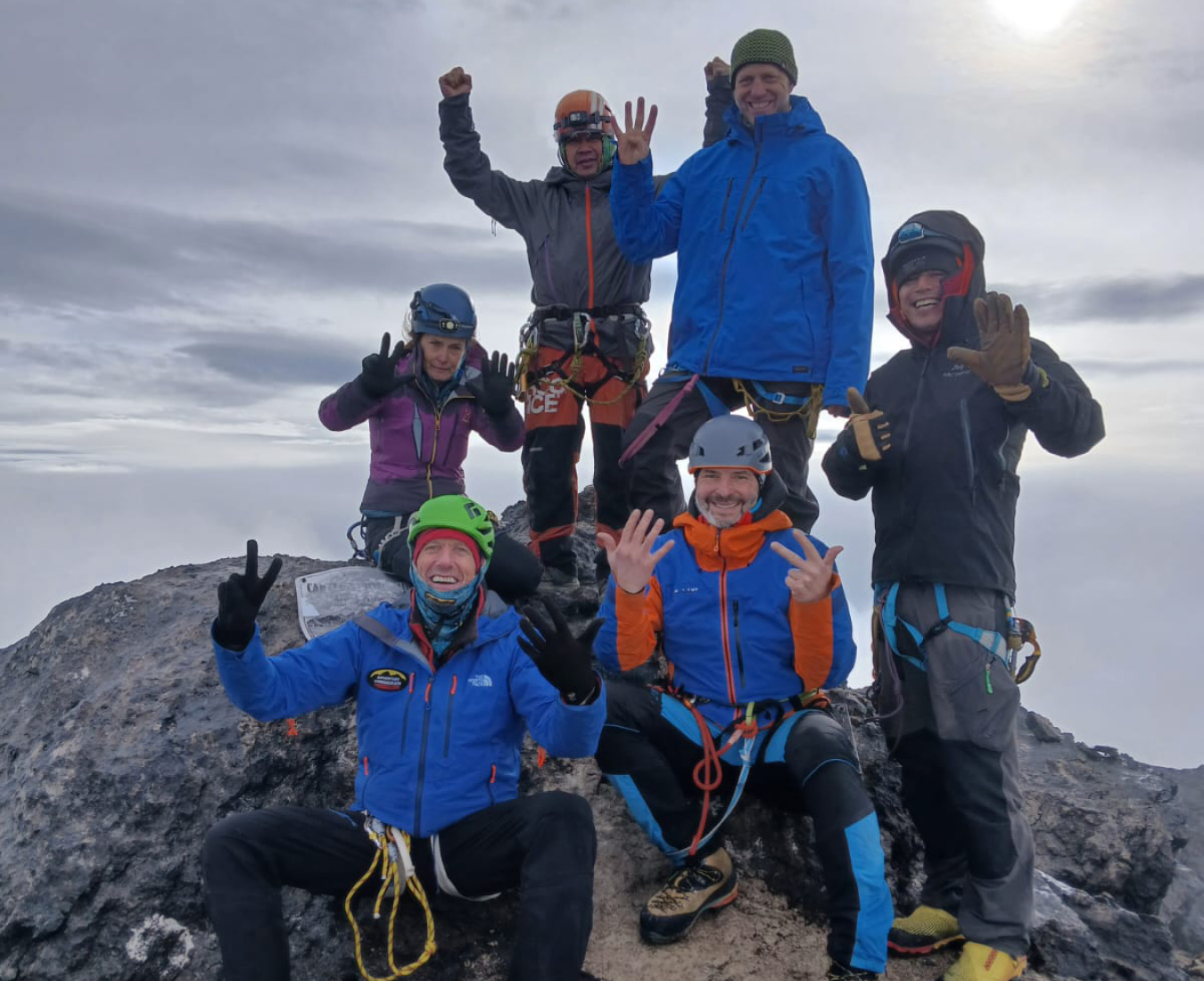 AC's Carstensz Pyramid team celebrate on the summit of Carstensz Pyramid, holding up their fingers to show how many of the Seven Summits they have now climbed!