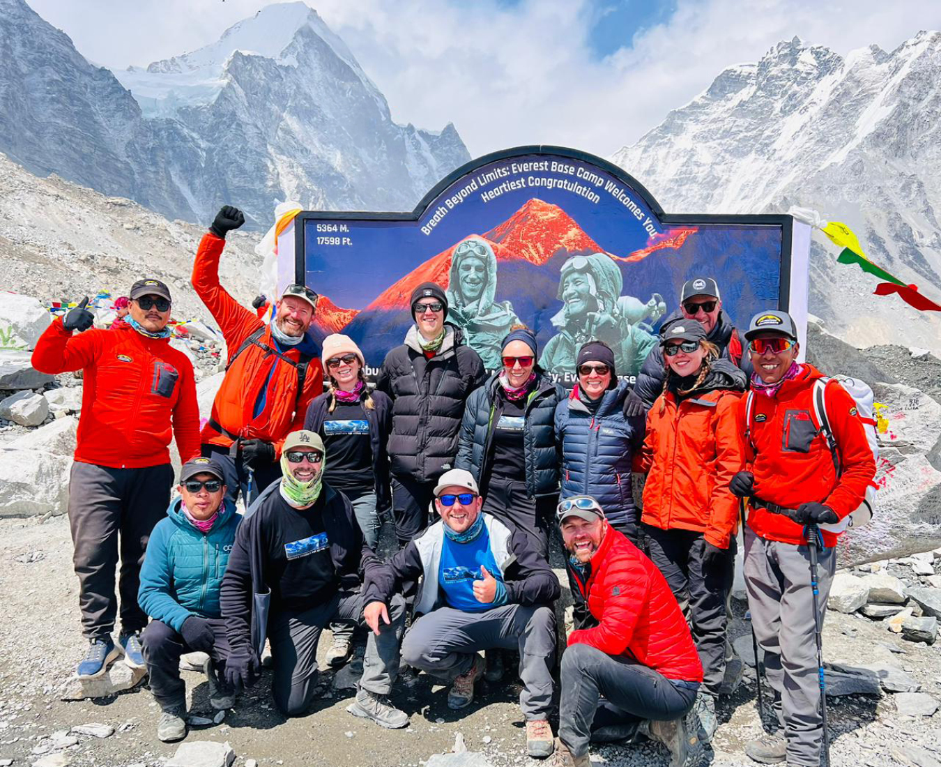 The AC Everest Base Camp Trek #1 team stand at the entrance to EBC, all smiles having reached their goal.
