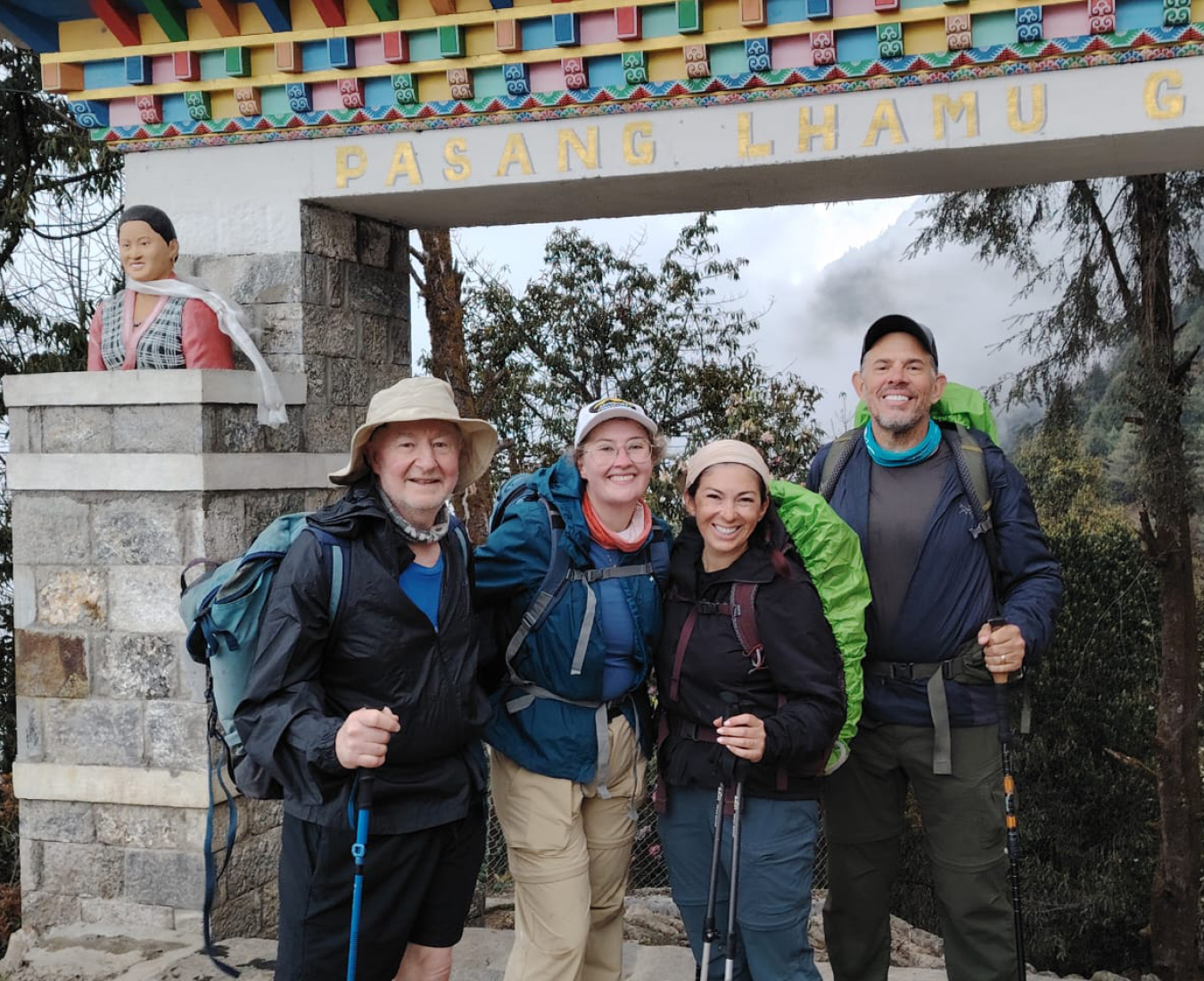 All smiles back at Lukla after a successful trek to Everest Base Camp a tired team stand beside the Lukla entrance gate.