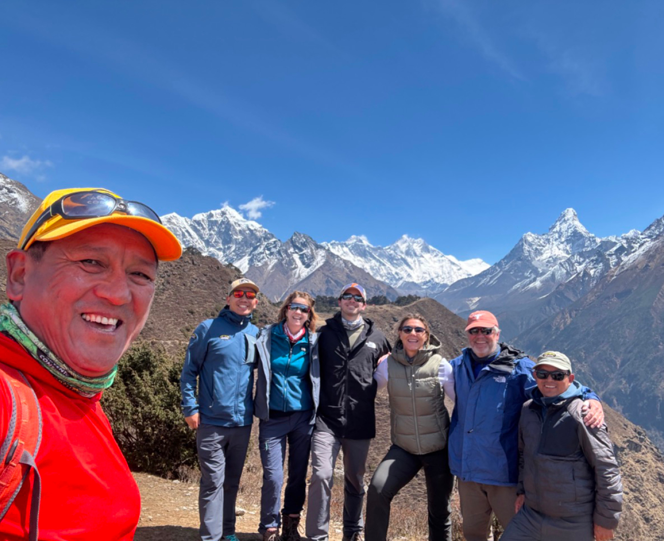 AC legend and mountain guide Ang Dorjee takes a selfie in front of his trekking team enroute to Everest base Camp. Ama Dablam, Lhotse Everest and more stand out in the distance behind the team.