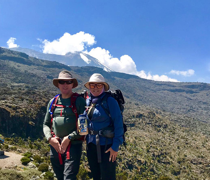 On the trail to Shria 2 Camp, the peak of Mount Kilimanjaro shrouded in cloud in the distance.