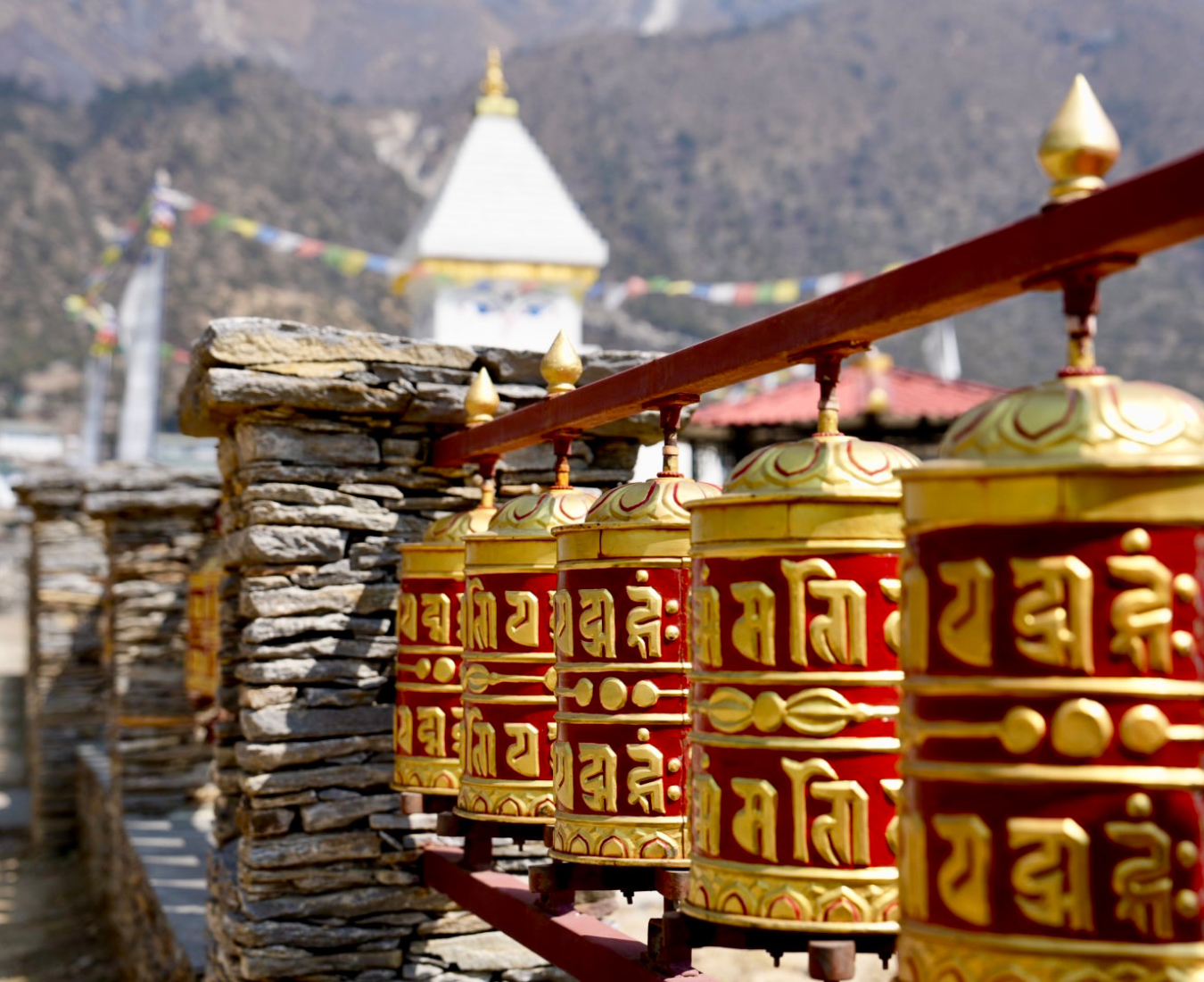 Brightly coloured red and gold prayer wheels adorn the trailside in the lower reaches of the Khumbu Valley.