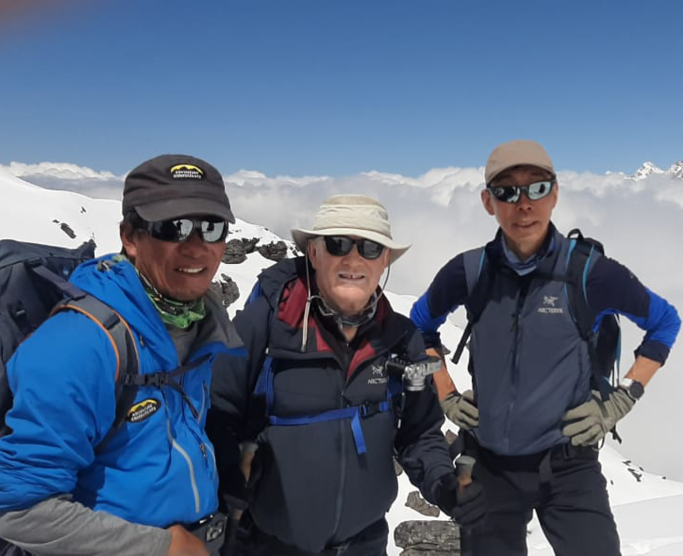 Two climbers and their Sherpa guide above the clouds on the Adventure Consultants Mera Peak Expedition.