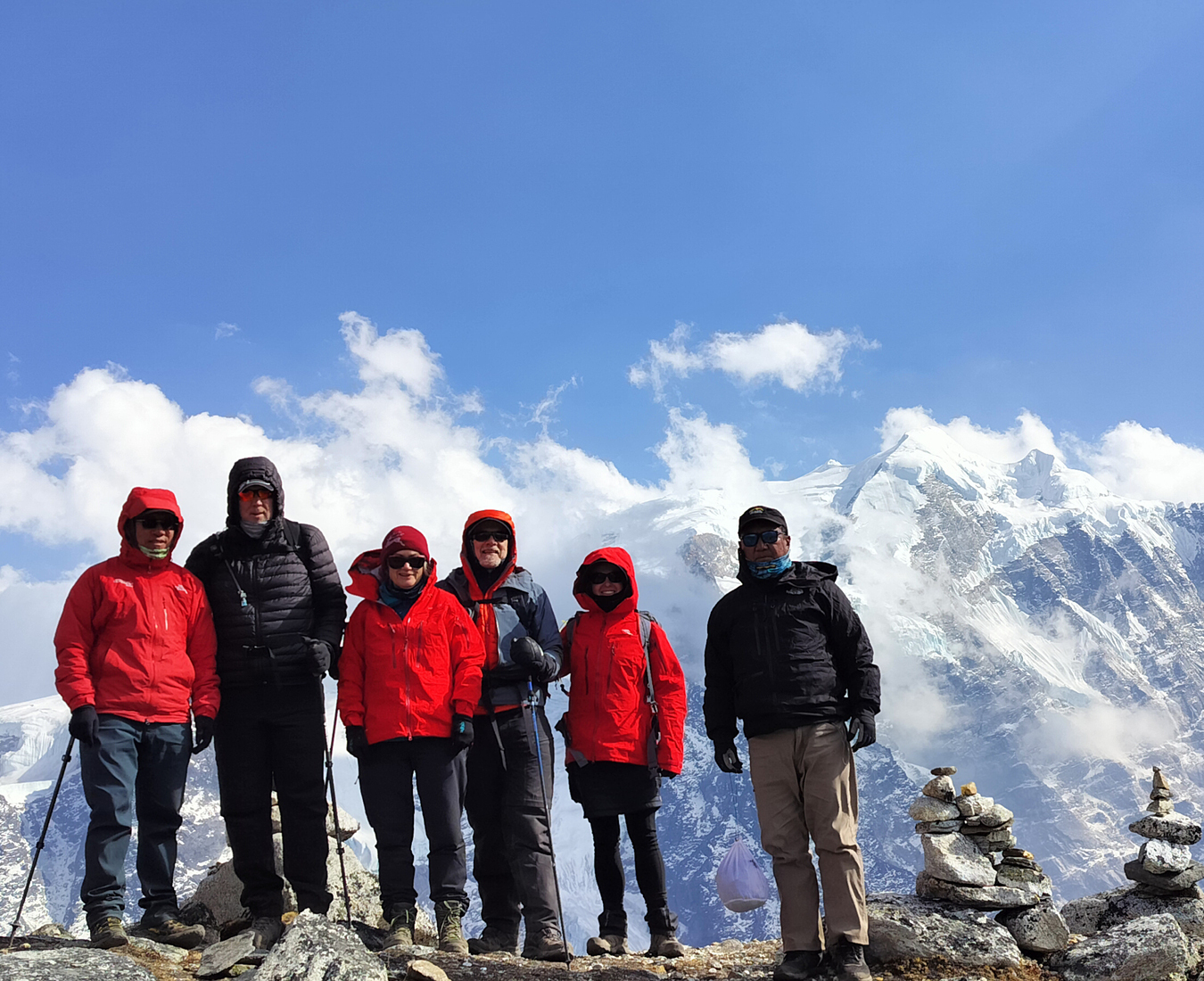 The AC Mera Peak team #1 2024 on an acclimatisation hike above Khare, stunning mountain vistas behind with patchy cloud.
