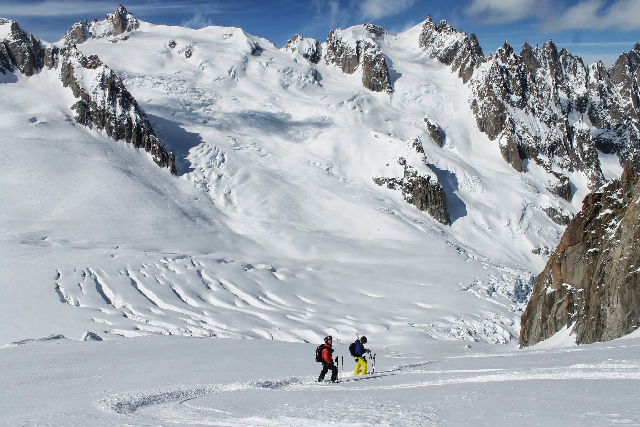 Skiers dwarfed by the surrounding mountains in Valle Blanche