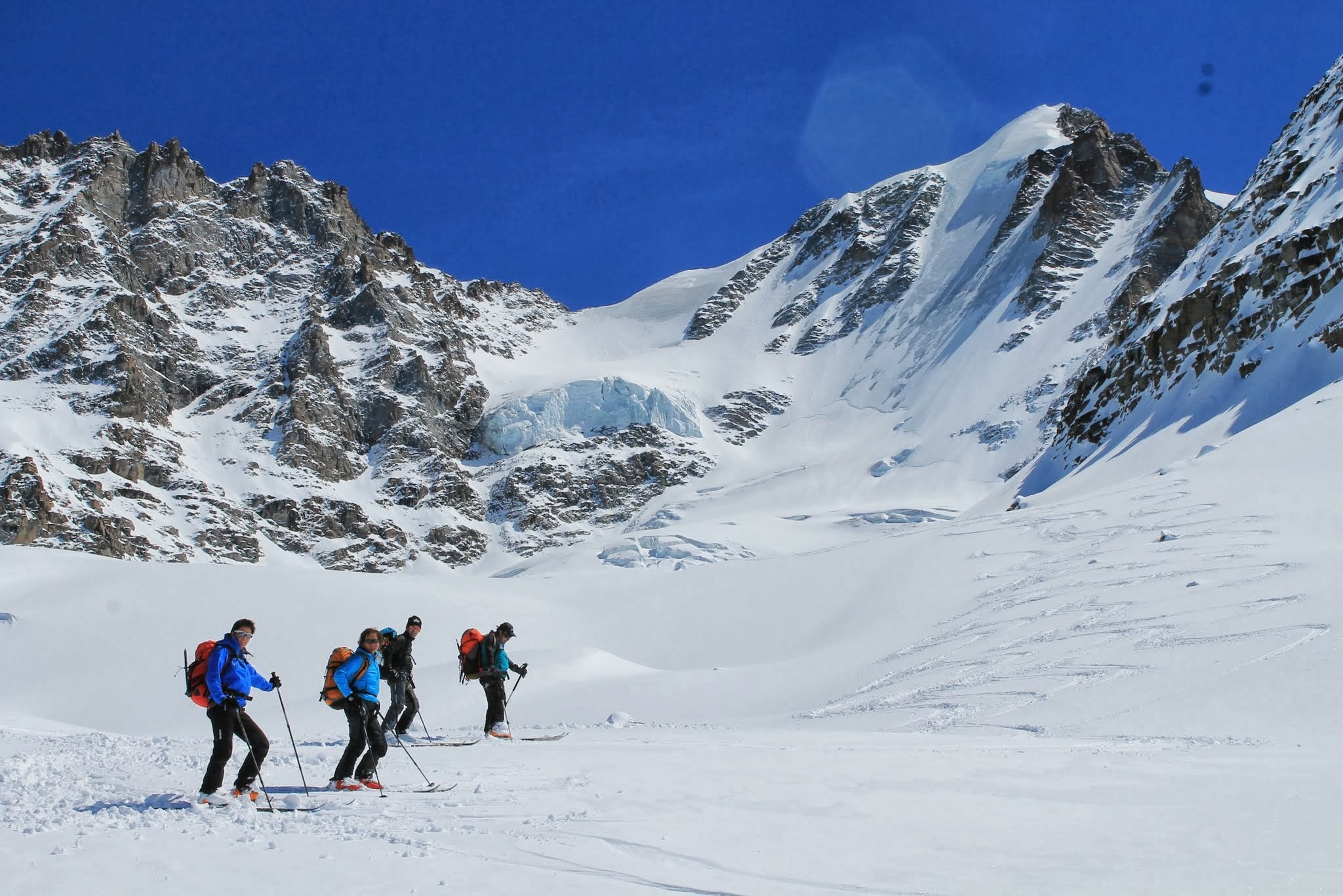 A groups of skiers meet at the bottom of a run by Paolo Pieroni