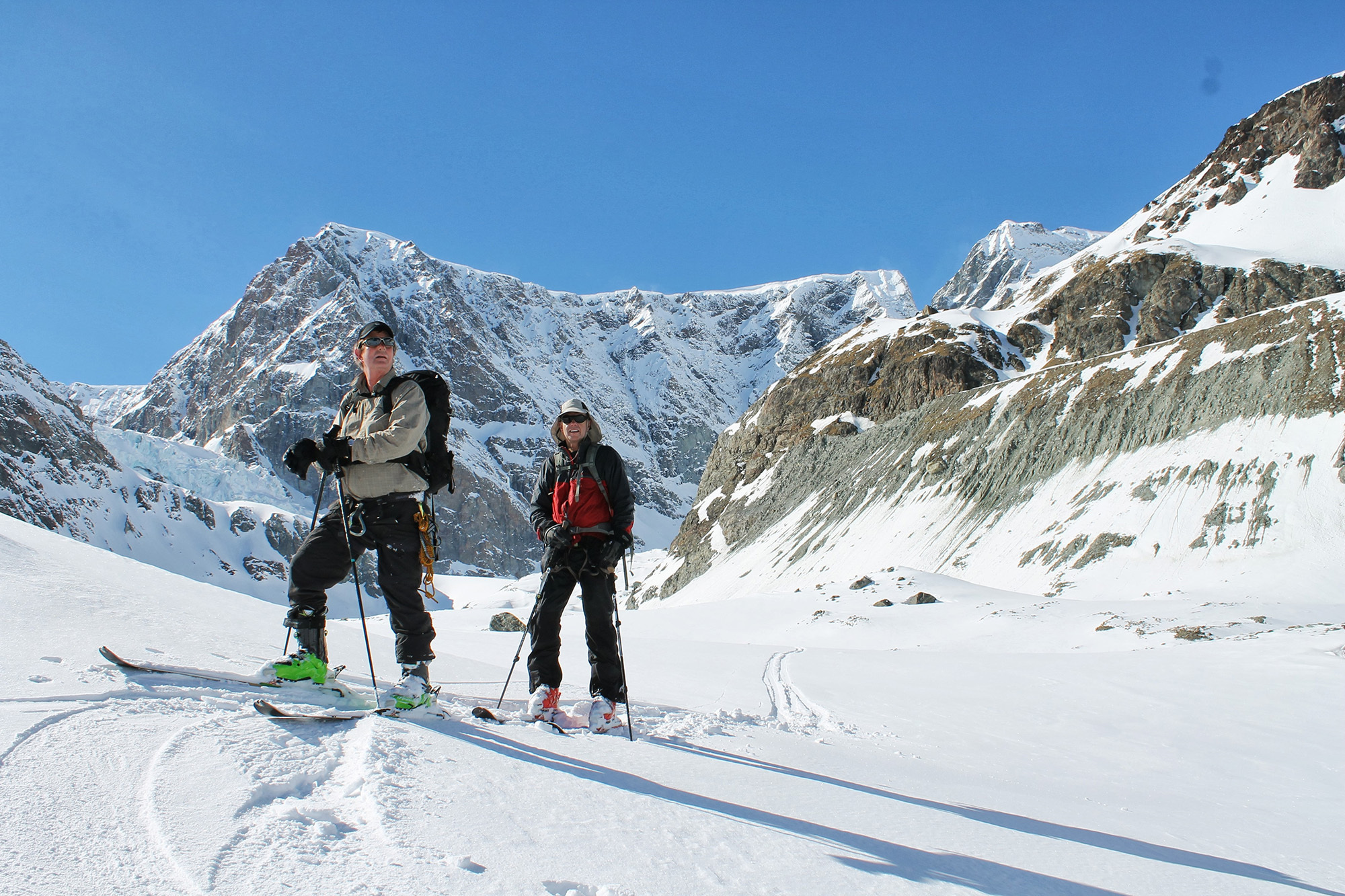 Two skiers stop and take in the enormous mountain scenery around them on the Haute Route.