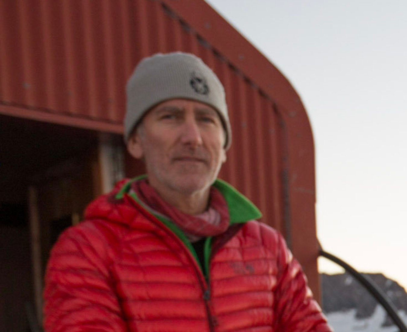 AC IFMGA Mountain and Ski Guide Andy Cole stands on the balcony of New Zealand's Colin Todd Hut in Mount Aspiring National Park.