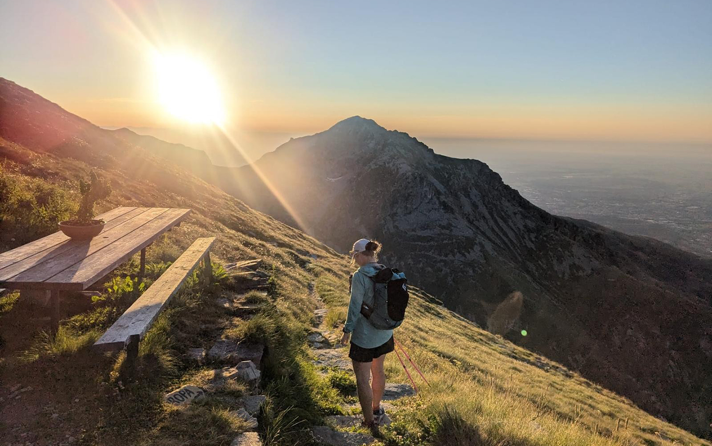 AC Trekking and ACMG Ski Guide Erika Flavelle ultra-running in the mountains with the sun on the horizon.