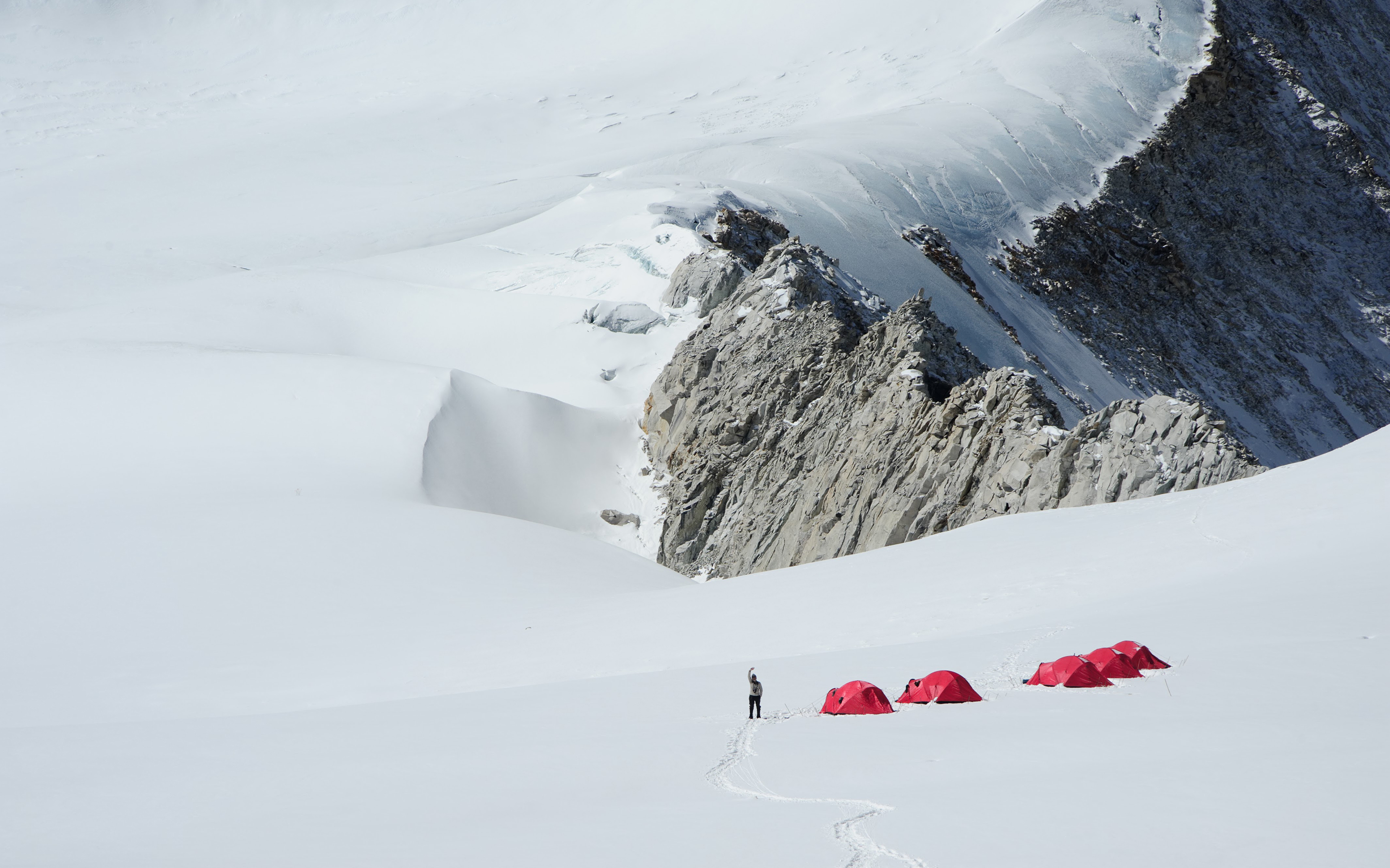 A climber waves from outside their tent high on the slopes of Baruntse at Camp 1.