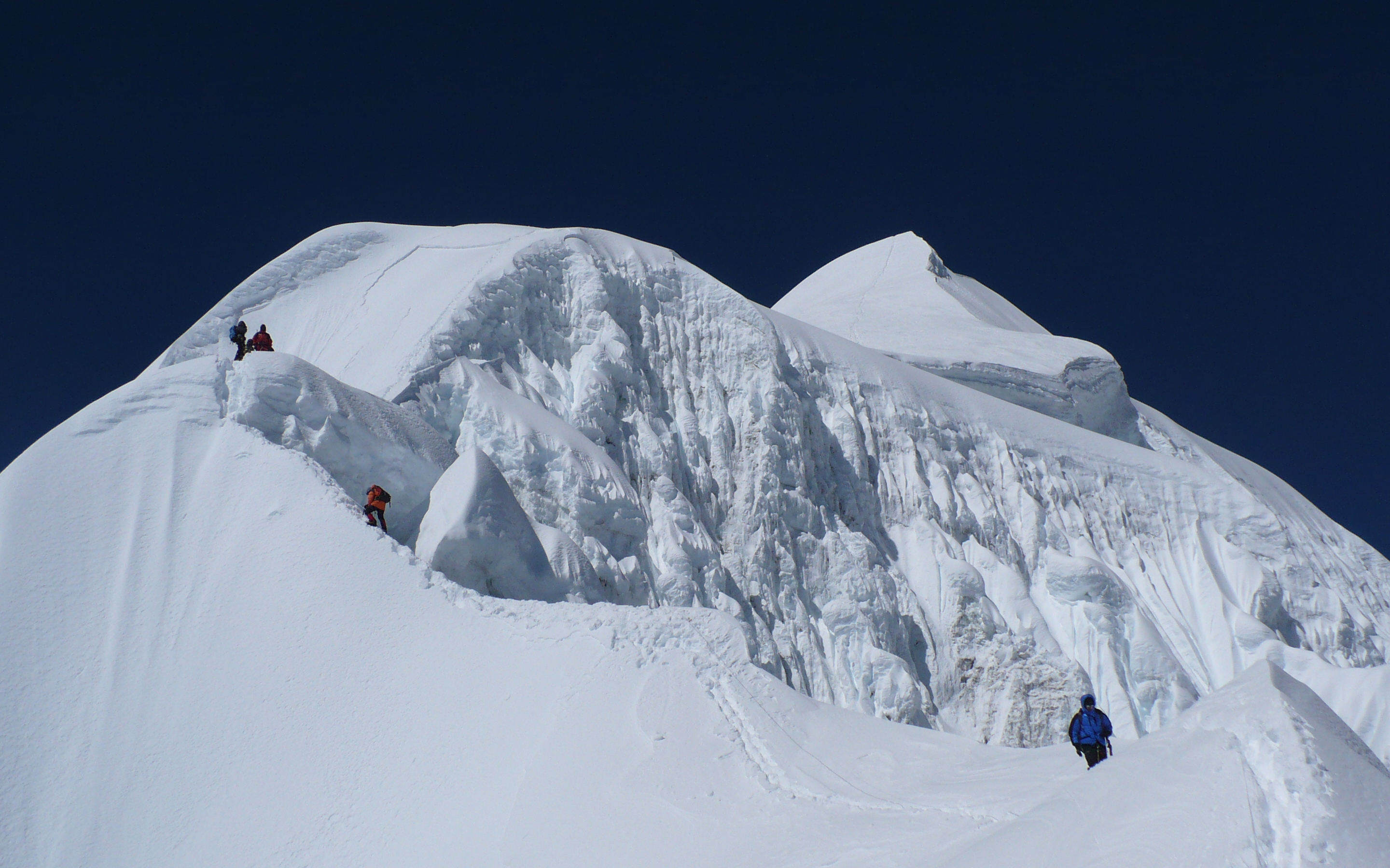 Climbers high on the snow covered South Ridge of Baruntse move up towards the summit.