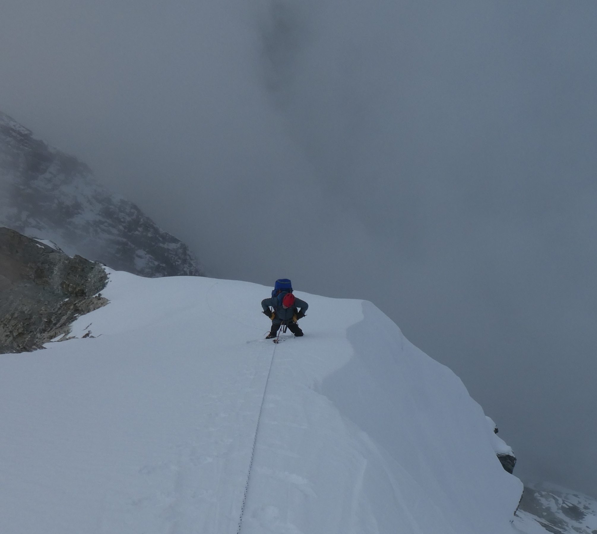 Looking down at a climber coming up the snowy upper slopes of Cholatse