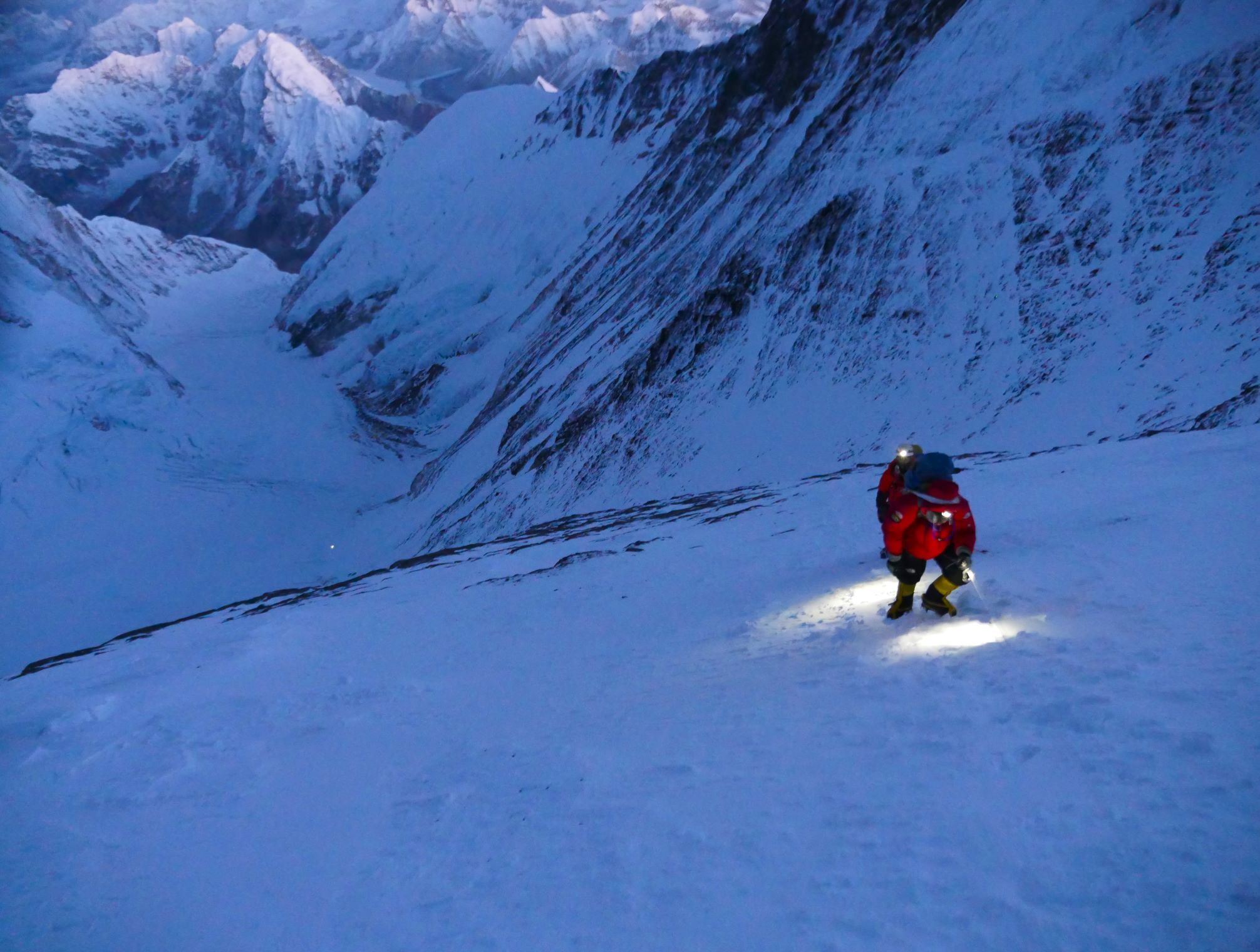 Climber with headlamp approaching gully on Lhotse in pre dawn