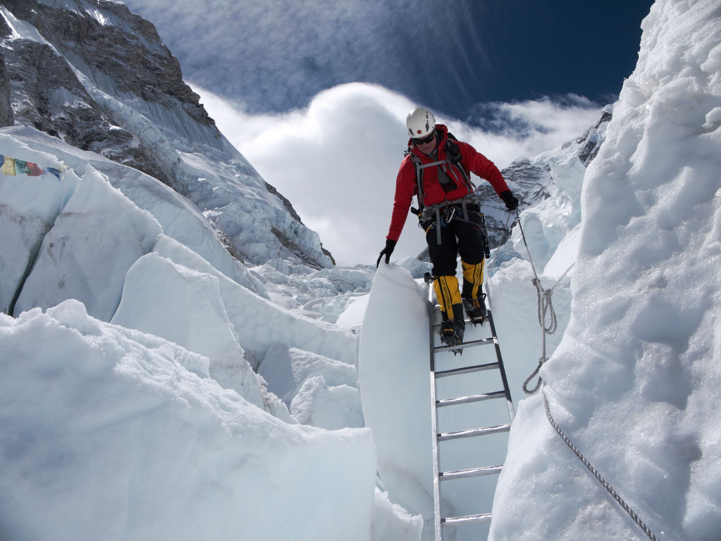 Climber descending a ladder in the Khumbu icefall on Mt Everest