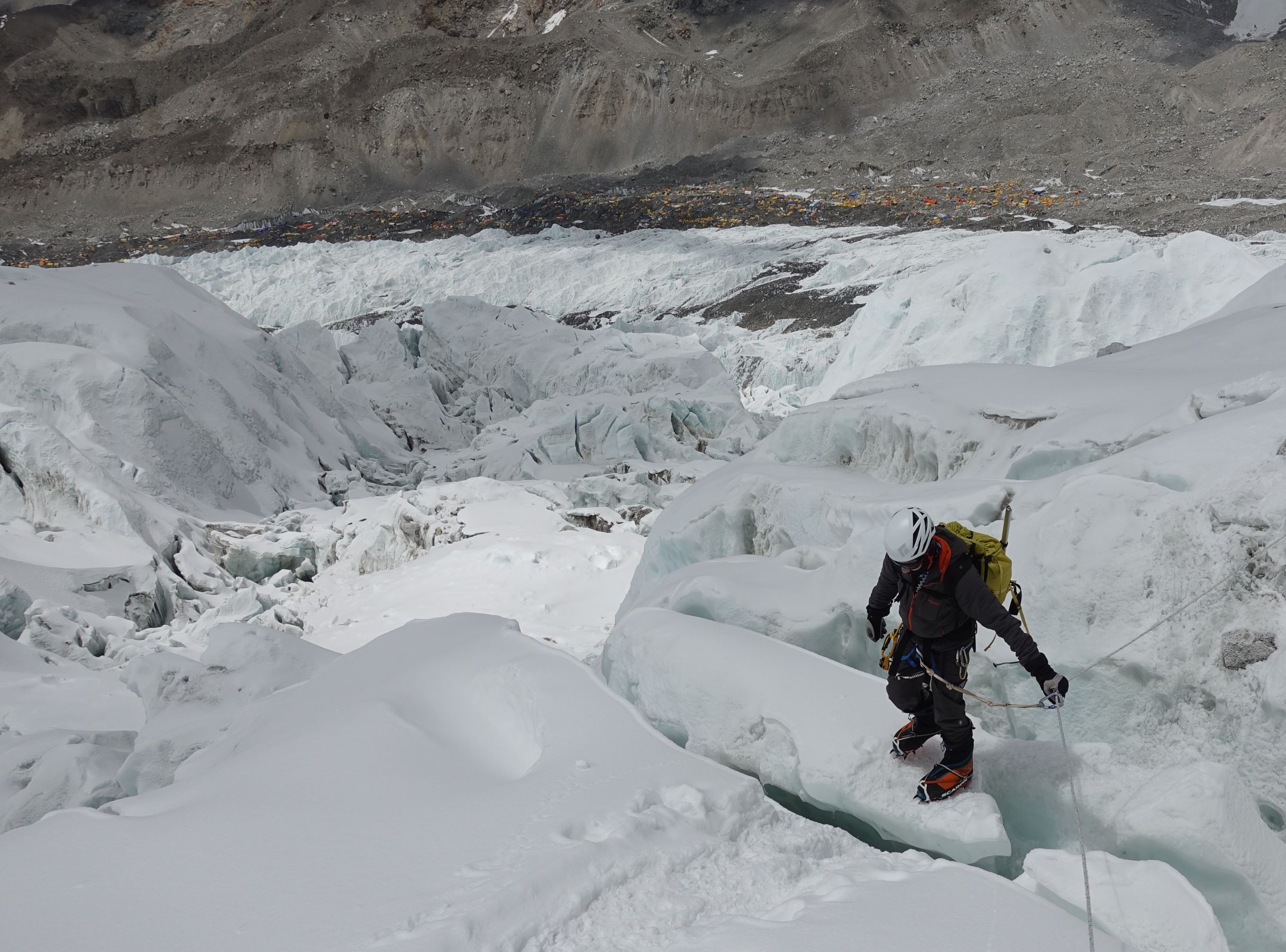 Climbing through the Khumbu icefall on Mt Everest with base camp behind