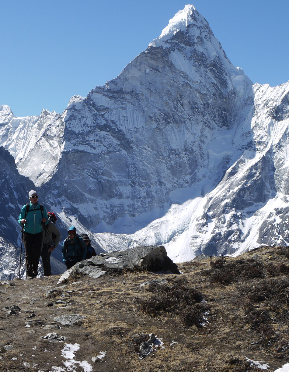 Trekkers make their way through the Khumbu Valley to Everest Base Camp. The majestic North Ridge of Mt Ama Dablam behind.