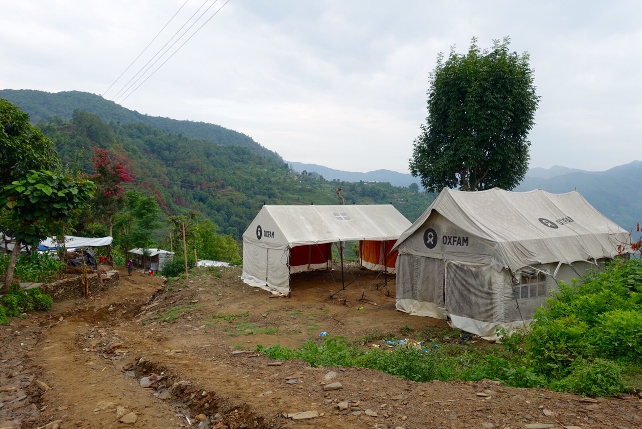 Oxfam relief tents stand on a hillside in Gorkha, providing temporary shelter and aid after the earthquake