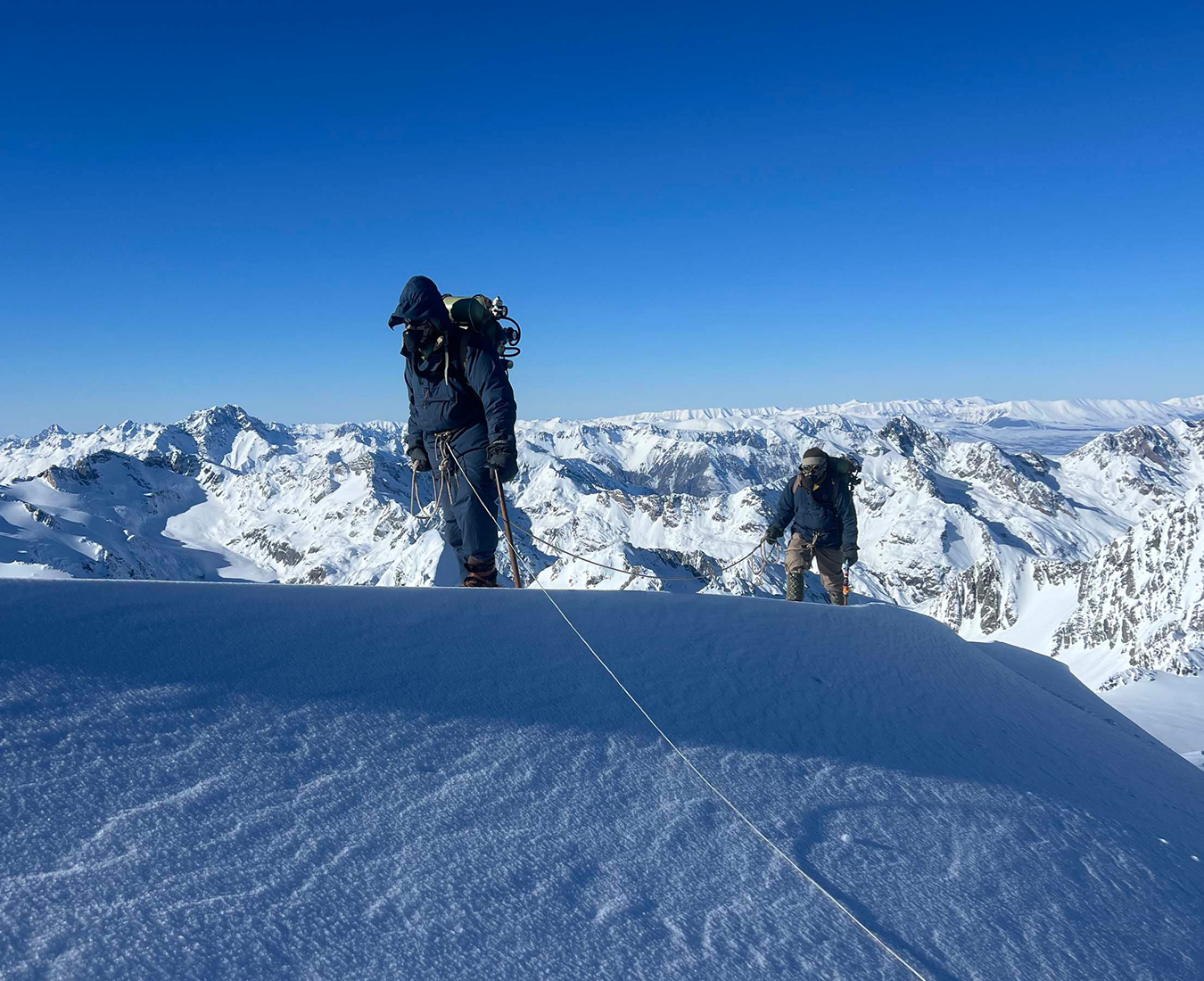 Two actors on the set of the Tenzing movie ascend a ridge line wearing clothing from the 1950s