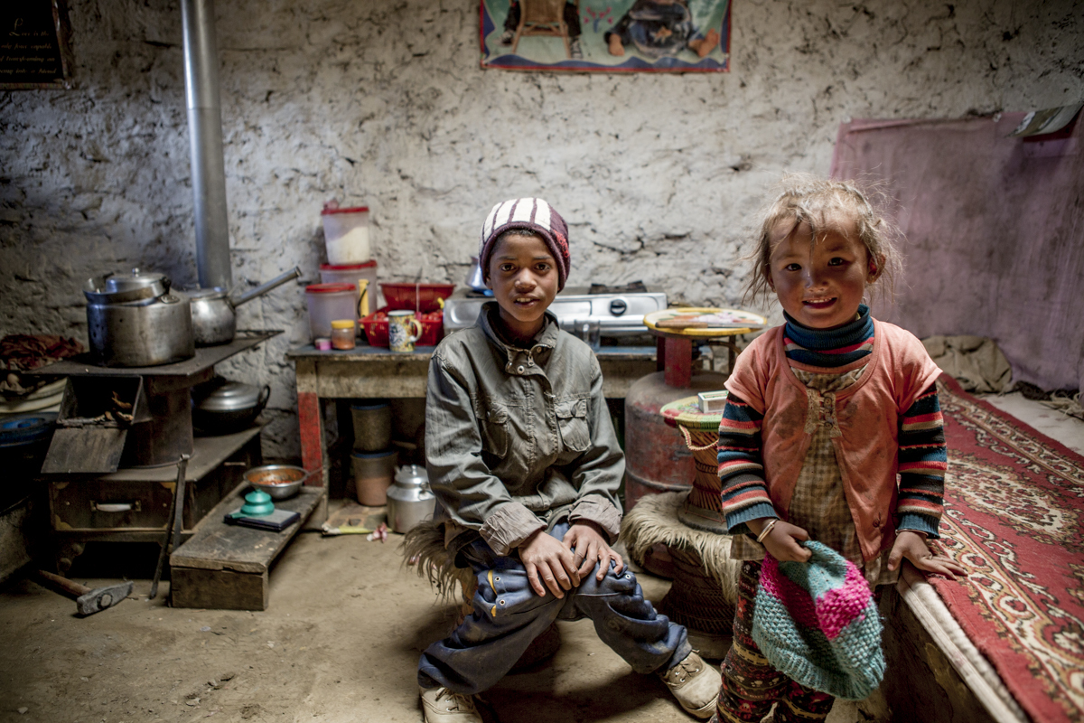 Two young children in the kitchen of their family home in Upper Mustang, Nepal.
