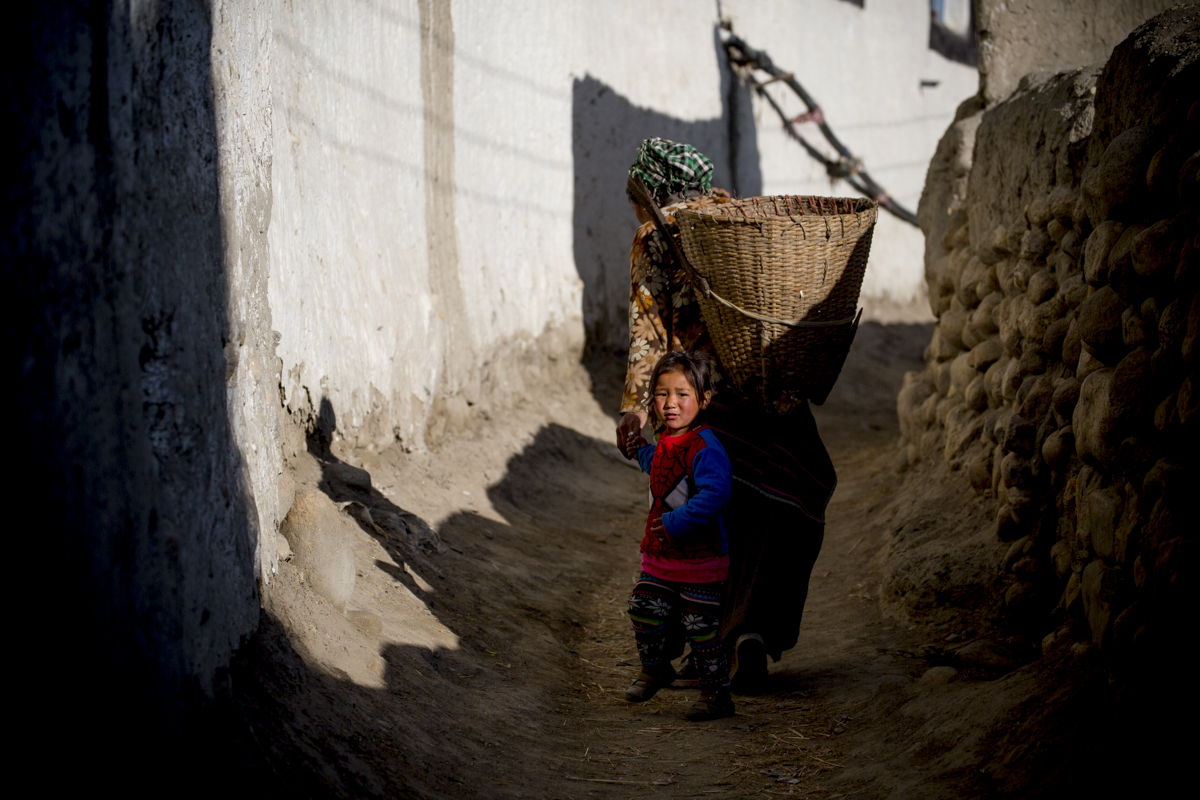 A small child wears a spiderman shirt, a stark contrast to the barren surroundings.