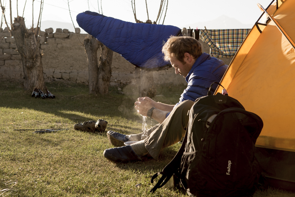 Taking an early morning wash outside the tent at the campsite in Lo Monthang, Nepal.