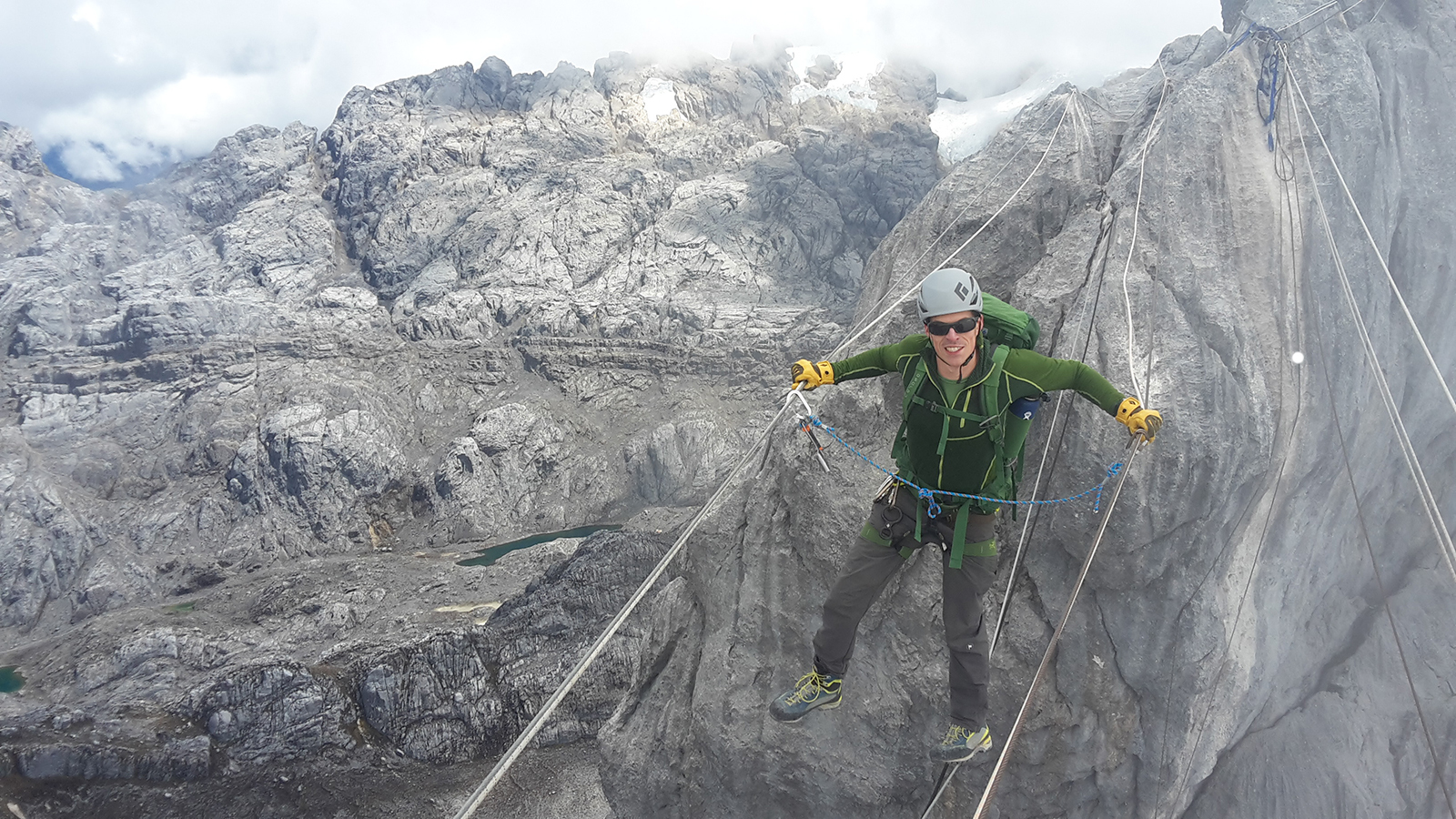 A climber crosses the 3-wire bridge enroute to the summit of Carstensz Pyramid
