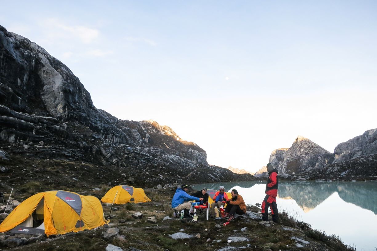 Climbers resting by a lake at Carstensz base camp