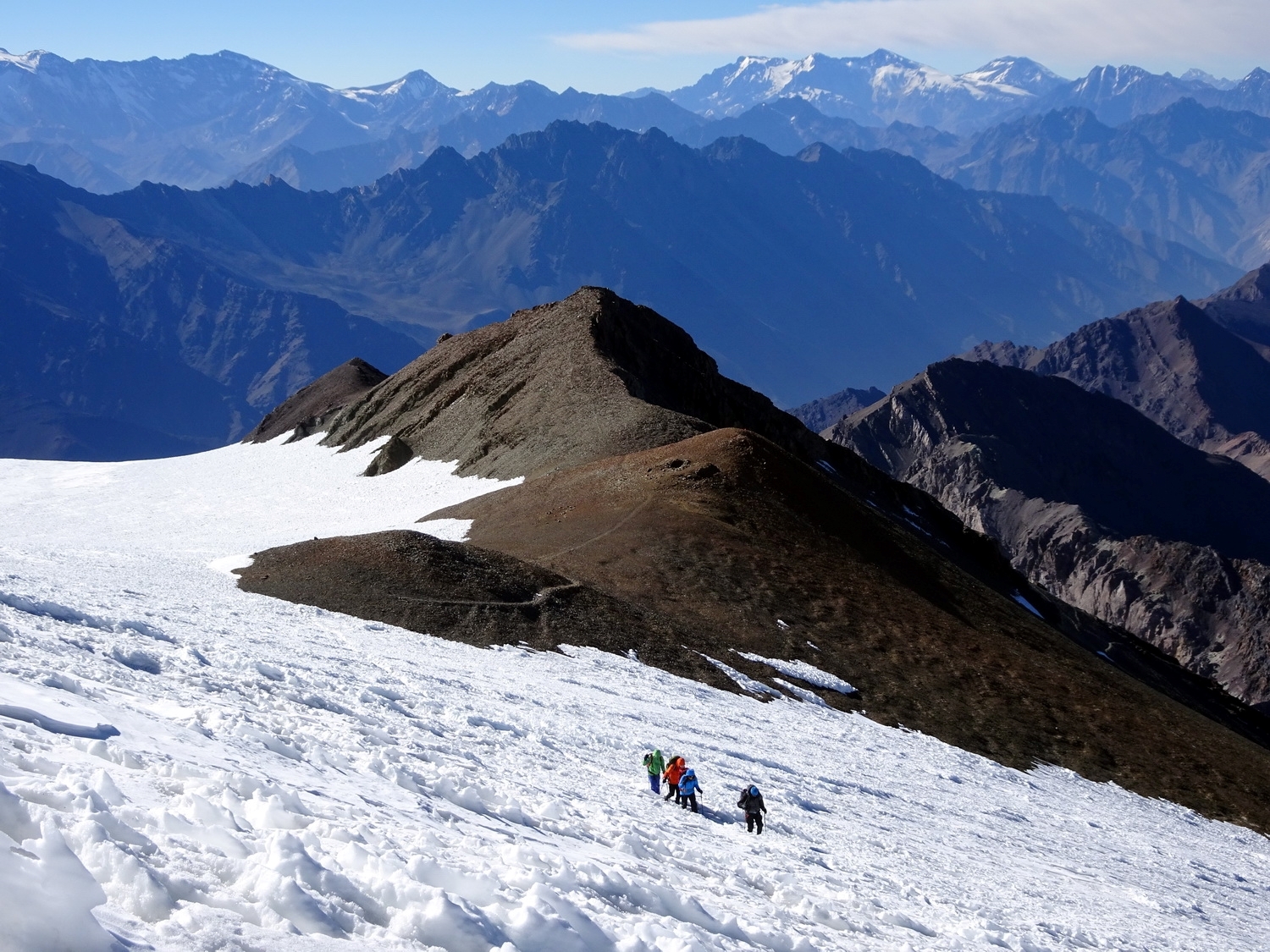 Looking down snow covered slopes to climbers on Cerro el Plomo