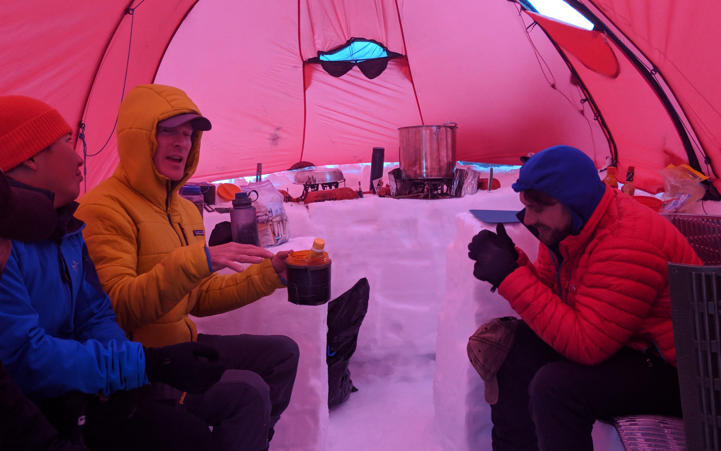 A guide entertains climbers while spending time inside their team kitchen tent on the Denali Perp course