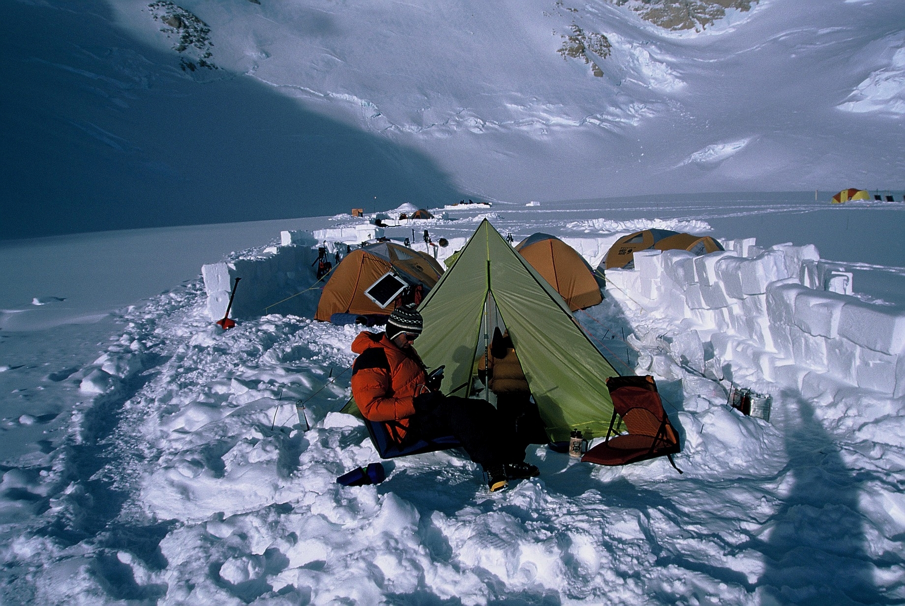 A tent camp on Denali, snow walls have been built to protect the camp.