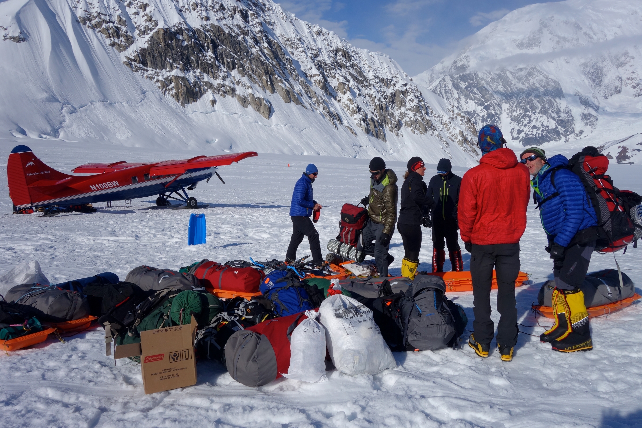 A ski plane lands and offloads climbers and their equipment at Denali Base Camp on the Kalhitna Glacier