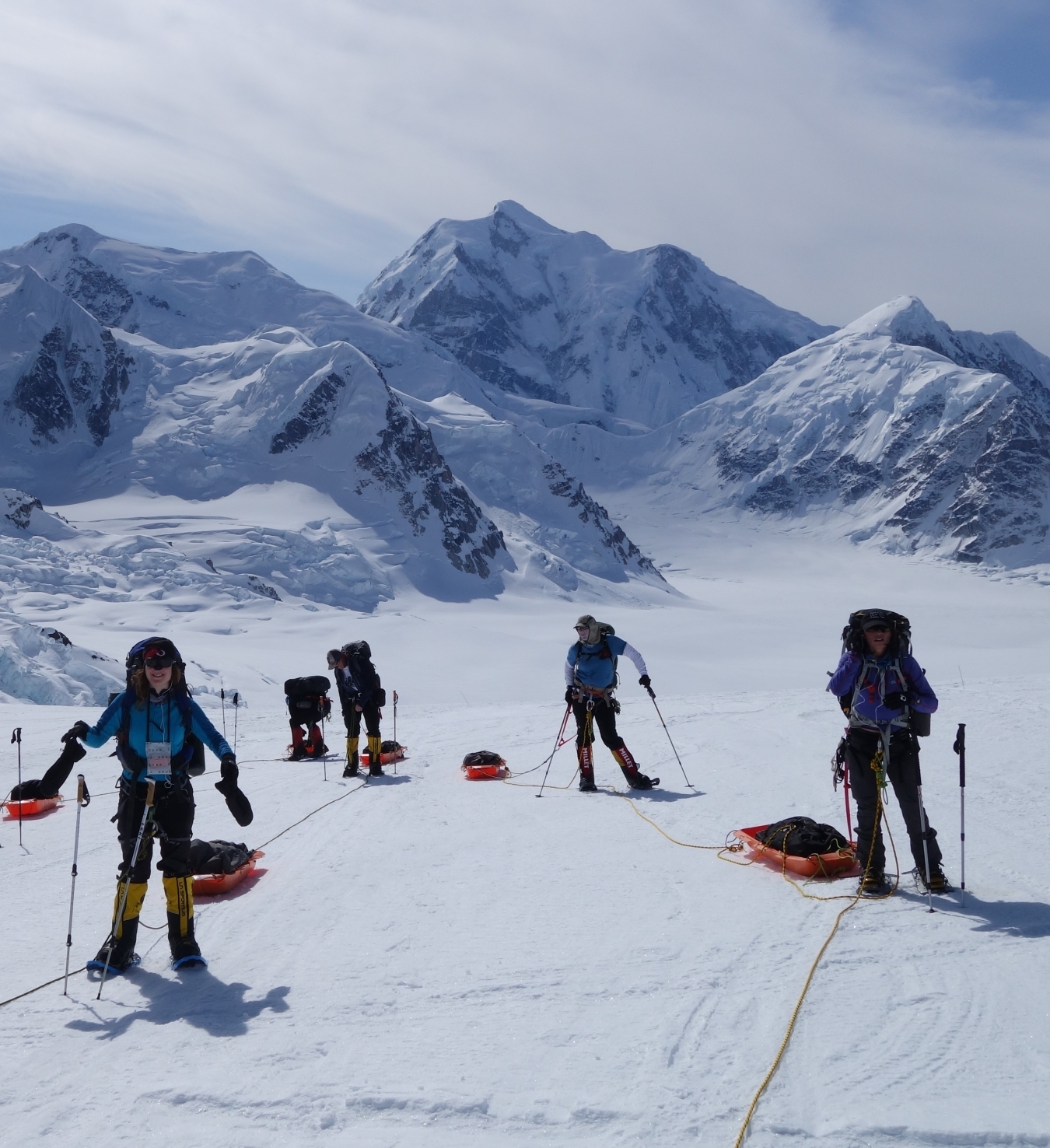 A team stop to rest while hauling sleds on the Kahiltna Glacier.