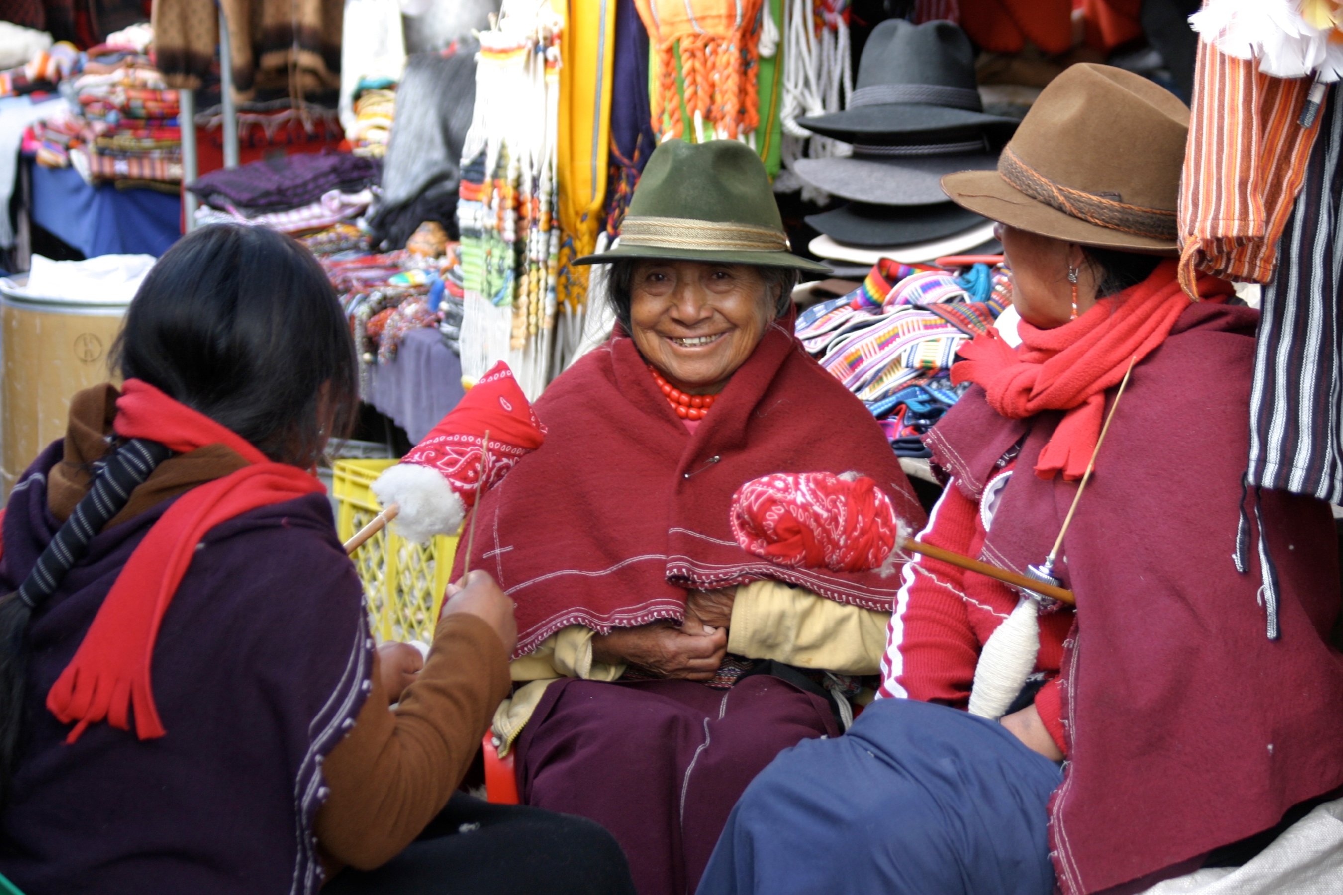 A group of local women sit in a market.